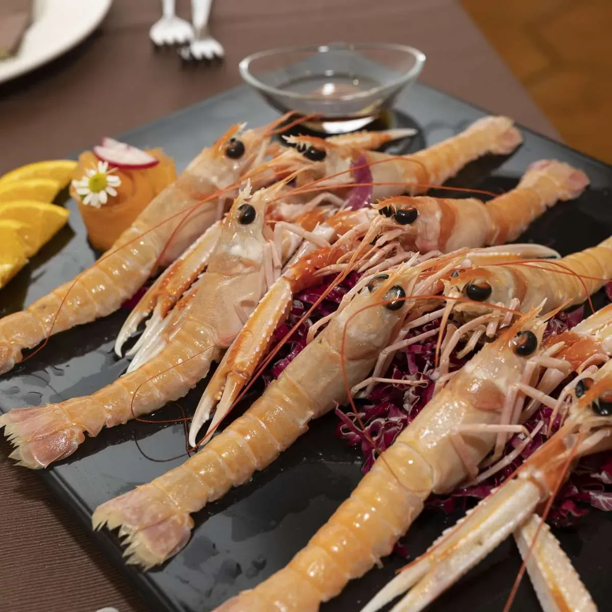 Gamberoni crudi su ardesia con agrumi e radicchio